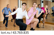 Young couple practicing vigorous lindy hop in choreography class. Стоковое фото, фотограф Яков Филимонов / Фотобанк Лори
