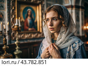 Portrait of a beautiful young woman in a headscarf in an Orthodox church. A girl prays in a church against the background of icons. Стоковое AI-изображение, AI-художник Photojuli / Фотобанк Лори
