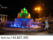 Gelendzhik, Russia - July 30, 2016 - Musical multicolored fountain on Lermontovsky Boulevard and vacationers on a warm summer evening. Редакционное фото, фотограф Андрей С / Фотобанк Лори