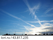 Chemtrail conspiracy theory. Long-lasting condensation trails left in sky by high-flying aircraft are actually chemtrails consisting of chemical or biological agents, sprayed for nefarious purposes. Стоковое фото, фотограф Юлия Петровская / Фотобанк Лори