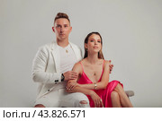 Elegant couple in modern attire posing in studio setting, showcase connection through subtle touches and poised expressions, enhances their elegance. Style fashion trendy concept. Copy ad text space. Стоковое фото, фотограф Aleksandr Golubev / Фотобанк Лори