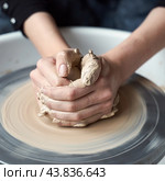 Woman making ceramic pottery on wheel, hands close-up, creation of ceramic ware. Handwork, craft, manual labor, buisness. Earn extra money, turning hobbies into cash and passion into job, close up. Стоковое фото, фотограф Natalia Gdovskaia / Фотобанк Лори
