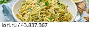 Banner with pesto pasta, bavette with walnuts, parsley, garlic, nuts, olive oil. Стоковое фото, фотограф Natalia Gdovskaia / Фотобанк Лори