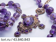 Elegant amethyst necklace on white surface. Стоковое AI-изображение, AI-художник Иван Рябоконь / Фотобанк Лори