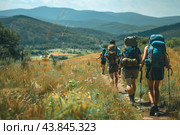 Group of Hikers Trekking Through Scenic Mountain Trail on a Sunny Day. Стоковое AI-изображение, AI-художник Сергей Толмачёв / Фотобанк Лори