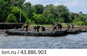 Российские военные собирают понтонный мост. Солдаты возводят плавучую железную переправу через реку Северский Донец. Инженерные войска вооруженных сил Российской Федерации. (2019 год). Редакционное фото, фотограф Евгений Зимин / Фотобанк Лори