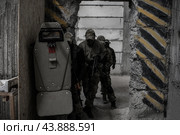 Отряд военных выстроился за солдатом с бронещитом и готовится штурмовать помещение. Стоковое фото, фотограф Евгений Зимин / Фотобанк Лори