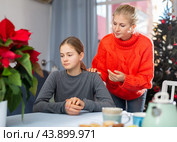 Mom soothes her teen daughter after a fight during Christmas holidays. Стоковое фото, фотограф Яков Филимонов / Фотобанк Лори