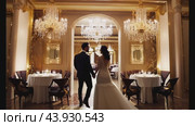 Luxurious restaurant interior with elegant bride and groom. Стоковое видео, видеограф Данил Руденко / Фотобанк Лори