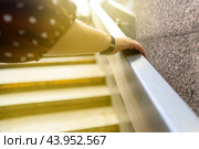 Woman hand reaches upward through metallic railings, striving to touch the sun. This image symbolizes hope, aspiration, and the pursuit of dreams against the constraints of modern life. Стоковое фото, фотограф Татьяна Степанищева / Фотобанк Лори