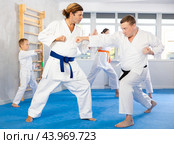 Man father is paired with coach to learn how to strike and rehearses blocking opponent. Стоковое фото, фотограф Яков Филимонов / Фотобанк Лори