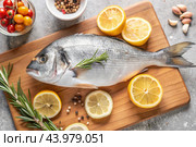 Delicious and healthy fish. Raw dorado with lemon and ingredients on a dark background. Banner, menu, place for recipe text, top view. Стоковое AI-изображение, AI-художник Photojuli / Фотобанк Лори