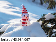 Забавный игрушечный снеговик на заснеженном фоне. Крупный план.  Funny toy snowman on snowy background. Close-up. (2022 год). Редакционное фото, фотограф Лариса Гордеева / Фотобанк Лори