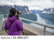 Nature photographer tourist with camera shoots. Stegastein Lookout. Beautiful Nature Norway. Стоковое фото, фотограф Андрей Армягов / Фотобанк Лори
