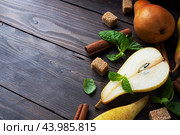 Ripe juicy yellow pears with cinnamon on wooden background. Conference pears for caramelization. copy space. Стоковое фото, фотограф Глущенко Елена / Фотобанк Лори