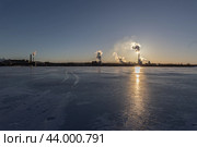 Joutseno, Finland - March 5, 2024: The paper factory in production during a clear evening weather in winter season. Silhouette of the building can be seen with the smoke coming from the pipe. Стоковое фото, фотограф Евгений Тарасенко / Фотобанк Лори