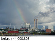 Lappeenranta, Finland - Aug 3, 2024: UPM Kaukas Pulp Mill factory with storm clouds and rainbow background. Редакционное фото, фотограф Евгений Тарасенко / Фотобанк Лори