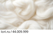 Soft white wool fibers arranged in a swirling pattern on a textured surface. Стоковое AI-изображение, AI-художник Сергей Толмачёв / Фотобанк Лори