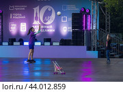 10-летие проекта «Активный гражданин». Точки активностей масштабного форума-фестиваля «Территория будущего. Москва 2030». Девушка аниматор с волейбольным мячом играет с мальчиком на сцене (2024 год). Редакционное фото, фотограф Константин Григорьев / Фотобанк Лори