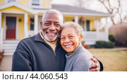 Happy elderly African-American couple near the background of their new house in the yard. Стоковое AI-изображение, AI-художник ALLA YURTAYEVA / Фотобанк Лори