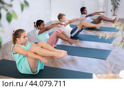 Girl perform boat asana - Paripurna navasana. Comprehensive hatha yoga class in mini group. Стоковое фото, фотограф Яков Филимонов / Фотобанк Лори