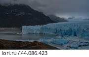 The famous Perito Moreno Glacier. A mass of cracked blue ice stretches to the horizon between the mountains. Thawed ice floes float in a glacial lake. Cloudy. Fog. El Calafate.Argentina.Lago Argentino. Стоковое фото, фотограф Вера Ивановна Кубарева / Фотобанк Лори