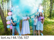 Семья с двумя детьми на вечеринке по поводу определения пола будущего ребенка "Гендер пати" узнает, будет ли у них мальчик или девочка. Синий дым или краска холи из хлопушки. Это мальчик! Стоковое фото, фотограф Яна Проничева / Фотобанк Лори