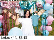 Красивая 41-летняя женщина на вечеринке по выявлению пола ребенка. «Это мальчик», беременная женщина держит снимок УЗИ и боди для мальчика. беременность после 40. Стоковое фото, фотограф Яна Проничева / Фотобанк Лори