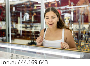 Young woman making choice against the background of stand with swords. Стоковое фото, фотограф Яков Филимонов / Фотобанк Лори