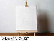 Blank canvas on wooden easel with copy space. Стоковое AI-изображение, AI-художник Иван Рябоконь / Фотобанк Лори