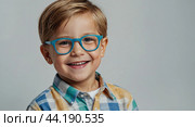 Portrait of a happy Caucasian kid preschooler with glasses on a solid gray background. Back to school, correction of pupil kid eyesight. AI generated. Стоковое AI-изображение, AI-художник Ольга Симонова / Фотобанк Лори