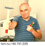Ordinary man posing with a hammer in his hands. Стоковое фото, фотограф Татьяна Яцевич / Фотобанк Лори