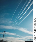 Chemtrail conspiracy theory. Long-lasting condensation trails left in sky by high-flying aircraft are actually chemtrails consisting of chemical or biological agents, sprayed for nefarious purposes. Стоковое AI-изображение, AI-художник Юлия Петровская / Фотобанк Лори