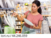 Asian woman choosing plates in store. Стоковое фото, фотограф Яков Филимонов / Фотобанк Лори