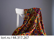 Красивый вязаный крючком плед на стуле на фоне серой стены. Стоковое фото, фотограф Дмитрий Петров / Фотобанк Лори