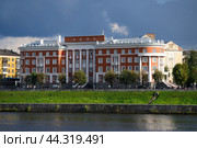Тверь, река Волга. Дом Ворошиловских стрелков на набережной. Stunning Tver cityscape view of Voroshilov building or house shooters at Stepan Razin embankment on Volga river at summer rainy day with dramatic sky and tourists walking. Tver tourism concept, Russia. Редакционное фото, фотограф Евгений / Фотобанк Лори