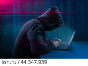 Dangerous Hooded Hacker Breaks into Government Data Servers. Cybersecurity, computer hacker with hoodie. Hideout Place has Dark Atmosphere. Hacking and malware concept. Стоковое фото, фотограф Павел Муравьев / Фотобанк Лори