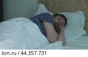 The man goes to sleep on his left side in bed and falls asleep. Стоковое видео, видеограф Ярославский Максим / Фотобанк Лори
