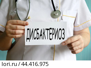 ДИСБАКТЕРИОЗ - слово на белом листе, который держит врач. Стоковое фото, фотограф Жанна Гапанович / Фотобанк Лори