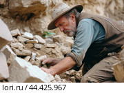 Focused archaeologist carefully unearths historical relics at an excavation site . Generate Ai. Стоковое AI-изображение, AI-художник Иван Рябоконь / Фотобанк Лори