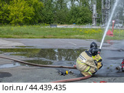 Пожарные удерживают пожарный ствол, когда подается вода под высоким давлением. Пожарные тушат пожар на нефтеперерабатывающем заводе. Тушение пожаров на технологических установках. Стоковое фото, фотограф Эдуард Белкин / Фотобанк Лори