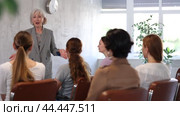 Emotional aged female tutor leading educational class for group of women sitting in auditorium. Стоковое видео, видеограф Яков Филимонов / Фотобанк Лори