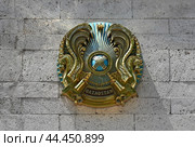 Coat of arms of the Republic of Kazakhstan on the Caspian University  building (2024 год). Редакционное фото, фотограф Алексей Кузнецов / Фотобанк Лори