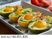 Baked avocado eggs with bacon bits. Стоковое AI-изображение, AI-художник Иван Рябоконь / Фотобанк Лори