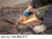 Metal cutting with a handheld machine with a cutting disc. Construction works. Hand tool, angle grinder. Стоковое фото, фотограф Дмитрий Кобзев / Фотобанк Лори
