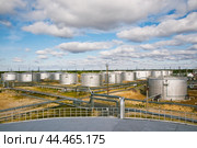 Нефтяные цистерны на фоне облачного неба. Стоковое фото, фотограф Павел Просянов / Фотобанк Лори