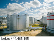 Нефтяные цистерны на фоне облачного неба. Стоковое фото, фотограф Павел Просянов / Фотобанк Лори