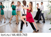 Woman dances incendiary tango with African man partner during choreography lesson. Стоковое фото, фотограф Яков Филимонов / Фотобанк Лори