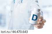 Doctor recommends taking vitamin D. Essential vitamins and minerals for humans. doctor gives vitamin D3. D alphabet Bottles with vitamins and dietary supplement. Стоковое фото, фотограф Павел Муравьев / Фотобанк Лори