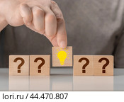 Concept creative idea and innovation. Hand picked wooden cube block with light bulb. Questions and answers. Creative idea. Стоковое фото, фотограф Павел Муравьев / Фотобанк Лори